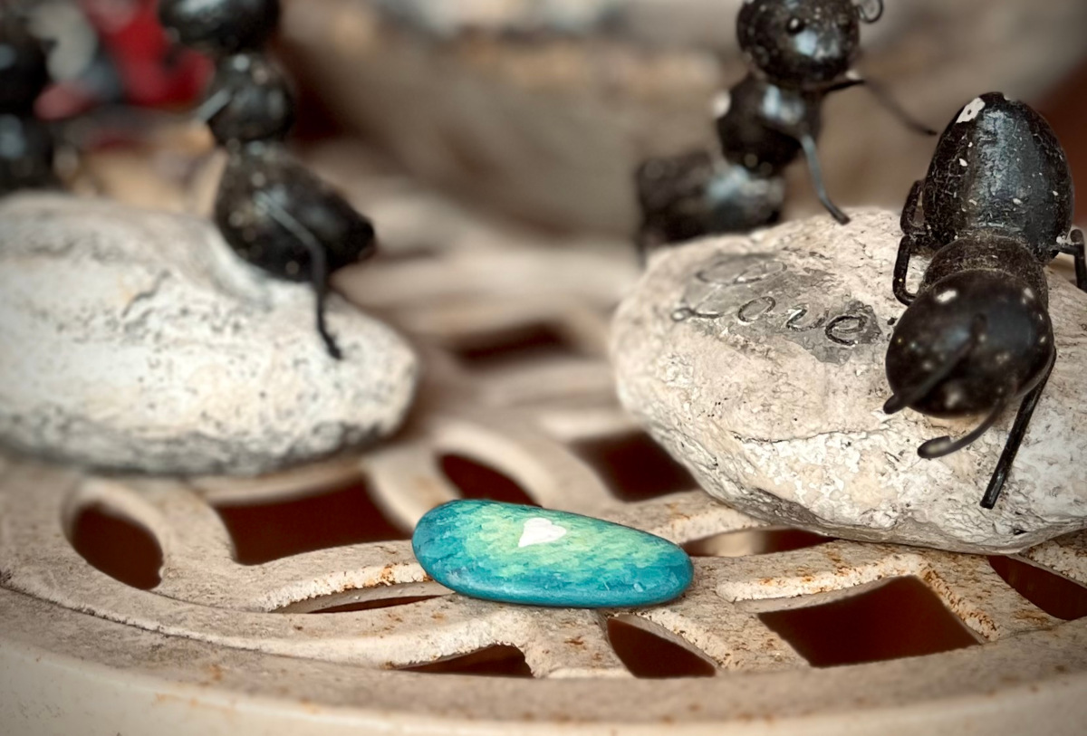 A stone, painted shades of emerald, with a heart.