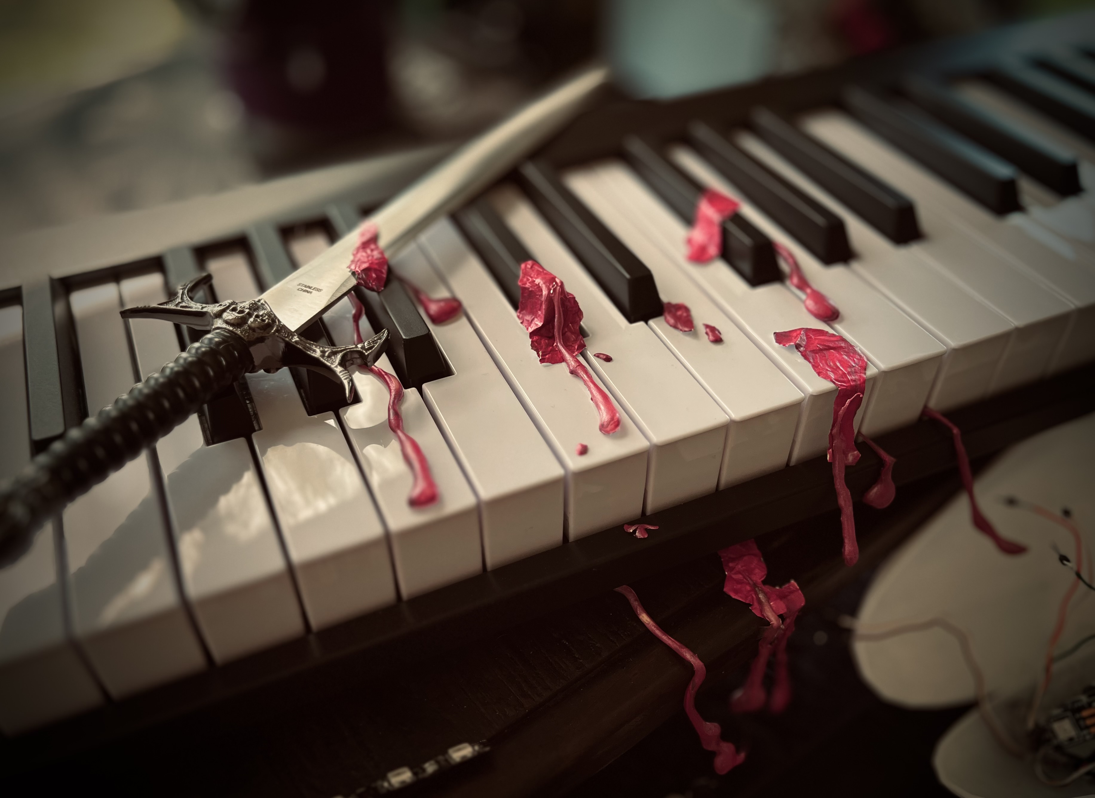 A keyboard, an athamé, and magenta fluid.
